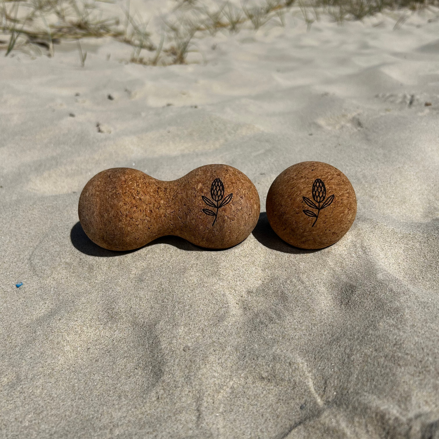 two cork balls on a sandy beach