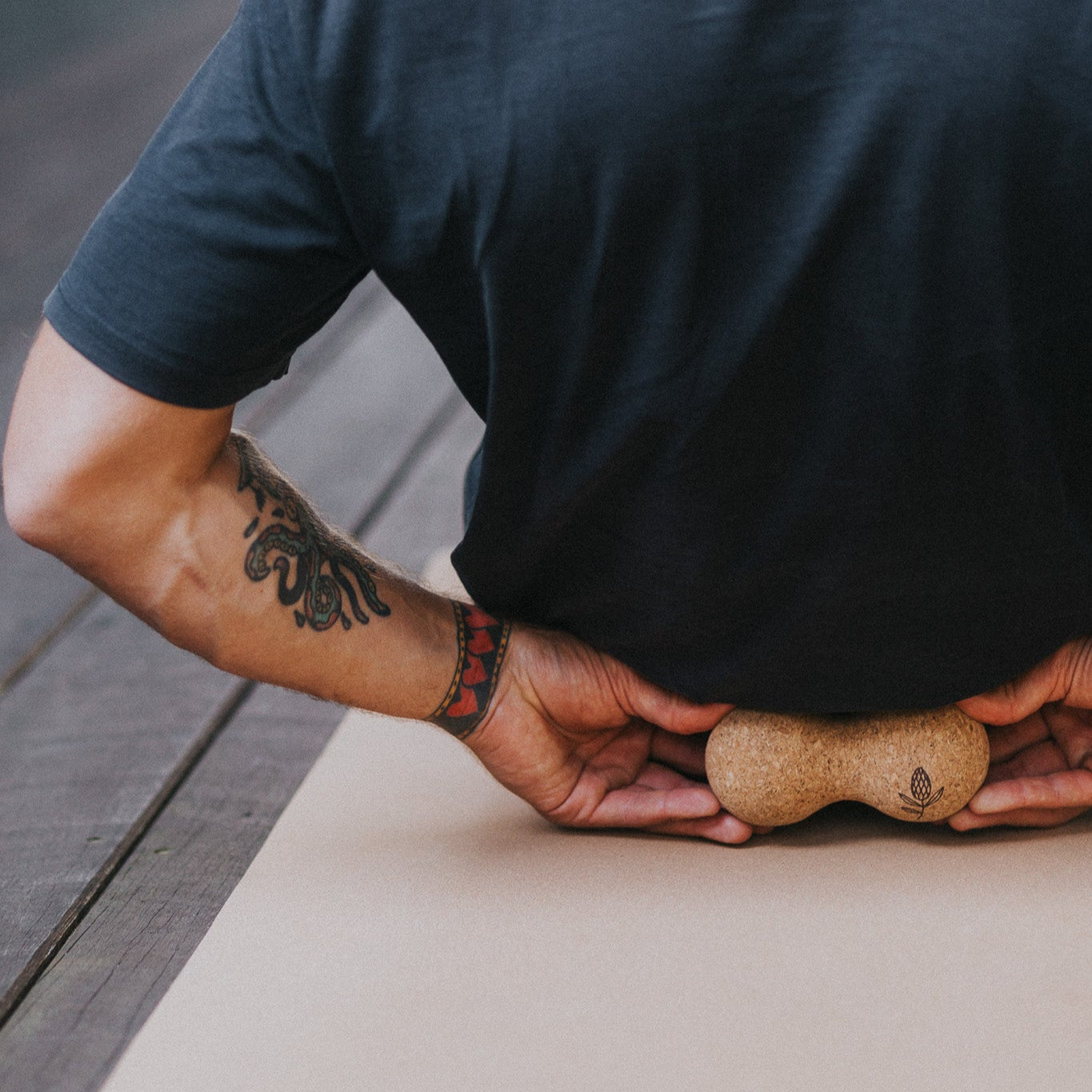 Person using a cork massage roller on a cork yoga mat.