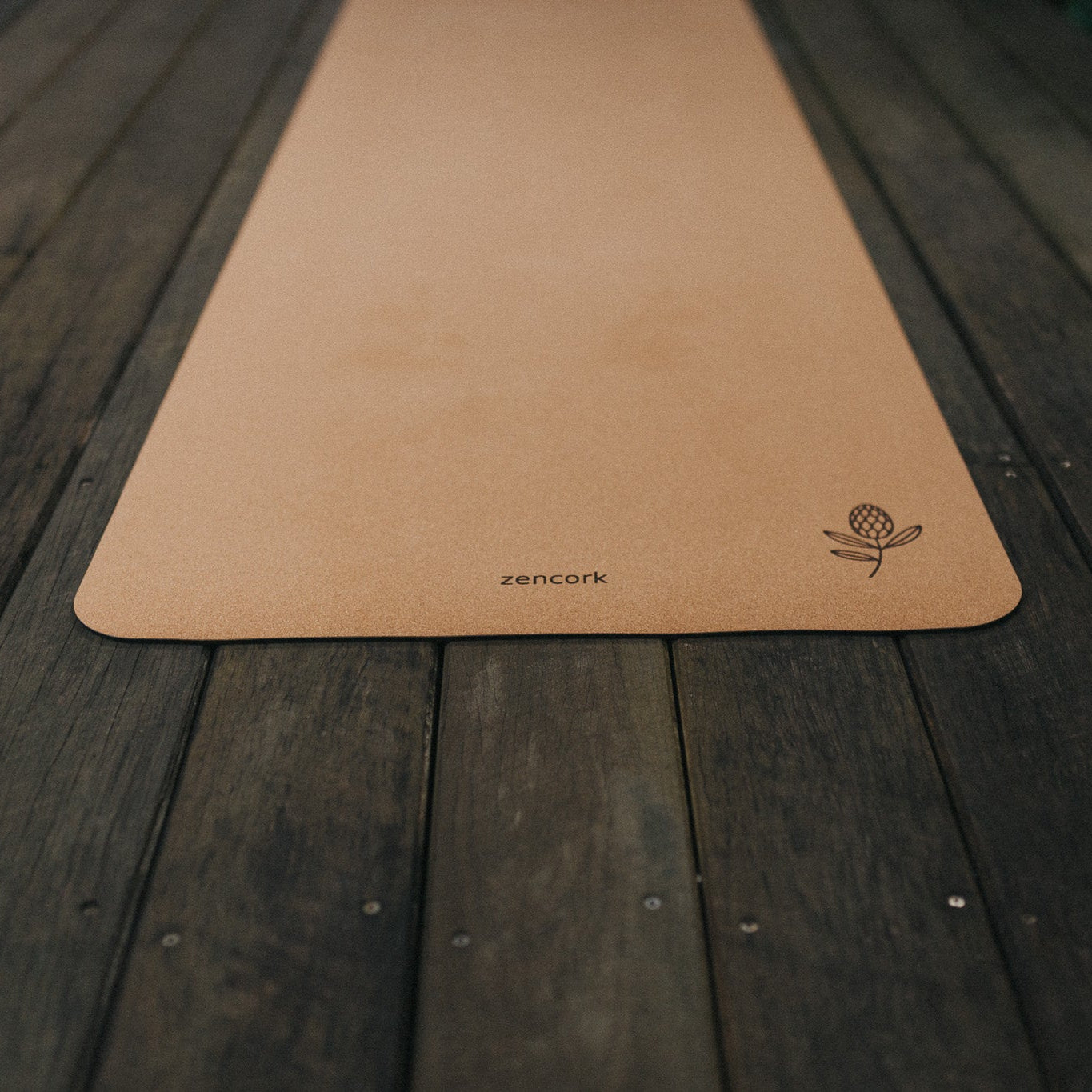 Brown yoga mat with a brand logo on a wooden surface
