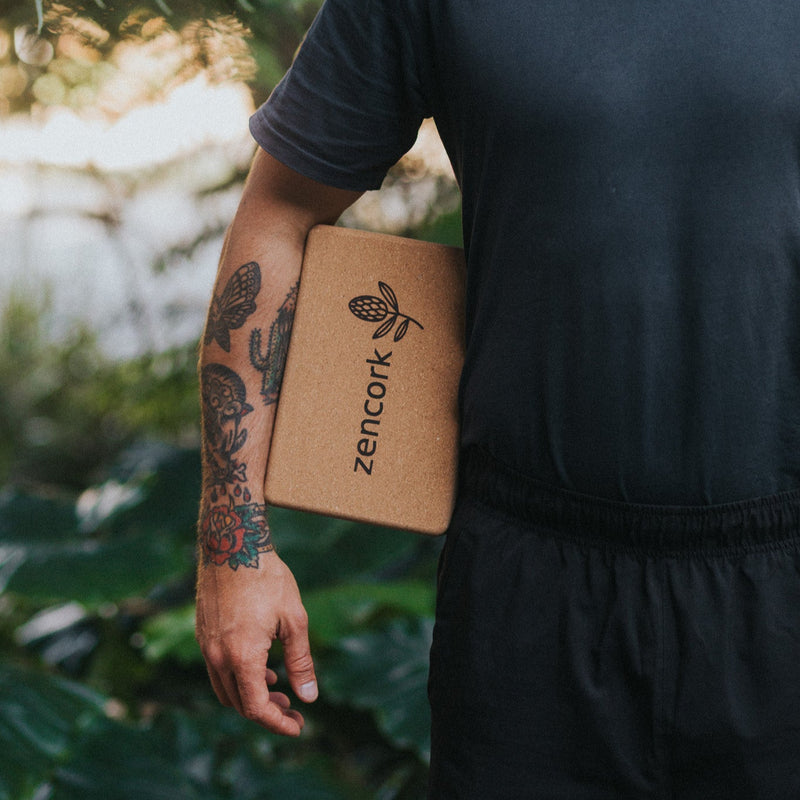 Man holding a cork product with 'Zencork' branding against a natural background