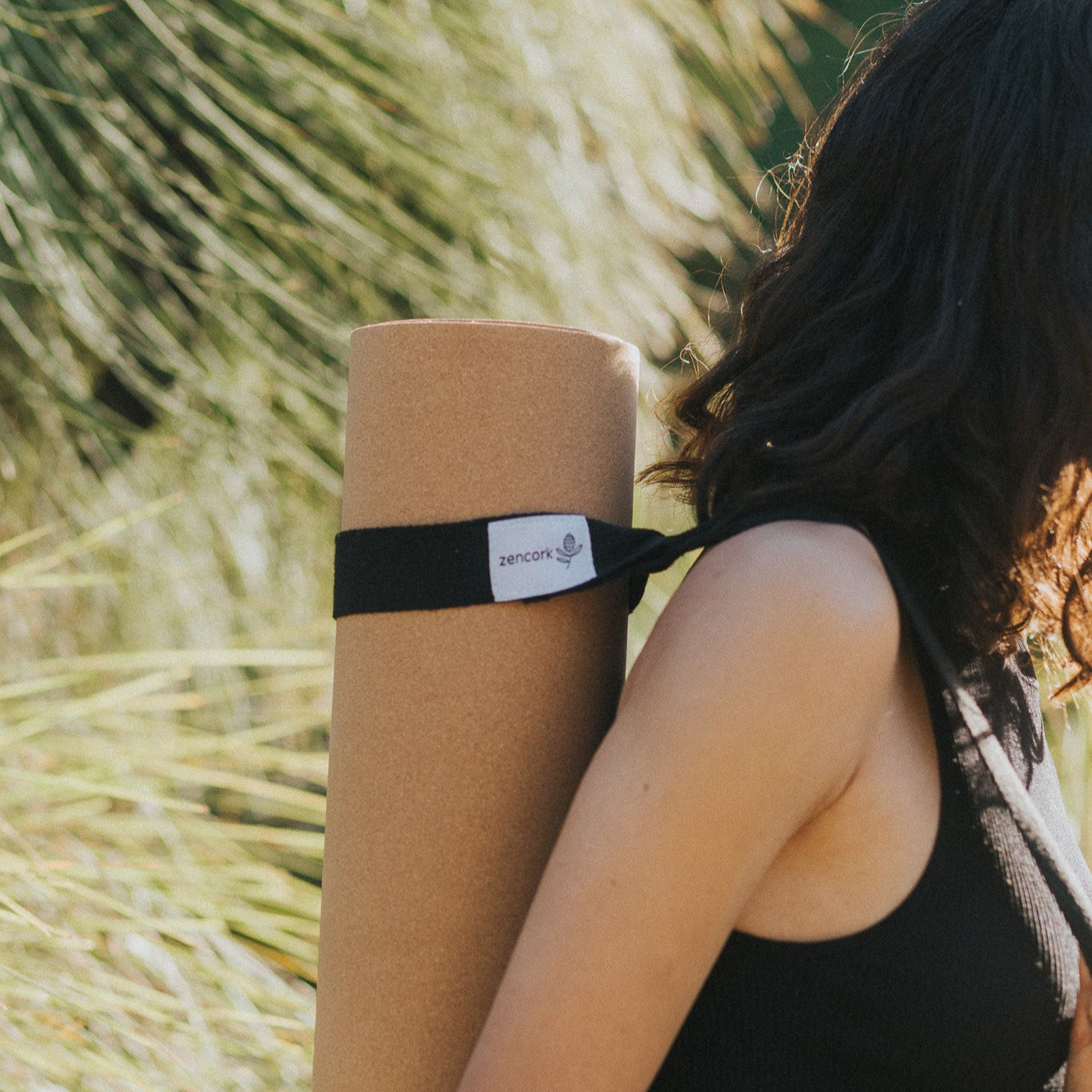 Person holding a yoga mat with a blurred natural background