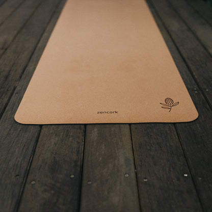 Brown yoga mat with a brand logo on a wooden surface