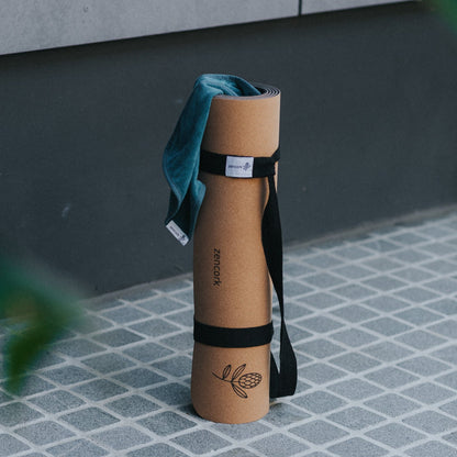 Yoga mat with strap on a tiled floor