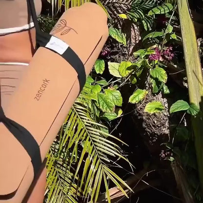 girl explaining why she loves the zencork coastal drift yga mat. performing yoga outside in from of green plants and doing yoga poses.